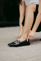 Chatitas de cuero con estampado animal print, con dos tiras cruzadas sobre el empeine y hebillas metálicas.