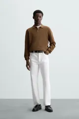 Polo marrón de corte relaxed fit, tejido en punto de algodón. Tiene cuello solapa con cierre frontal de botonadura, manga larga y acabados en rib.