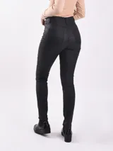 Pantalón chupín de cuero sintético color negro, tiro alto y corte ajustado.