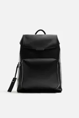 Mochila negra de cuero sintético con solapa y cierre magnético. Tiene un compartimento principal con espacio para dispositivos electrónicos de hasta 13 pulgadas y un bolsillo con cierre. En la parte frontal tiene un bolsillo con cierre y bolsillos planos en los laterales. La parte posterior es acolchada y tiene una banda de sujeción para equipaje. Tiene asa de mano y dos asas de hombro ajustables y acolchadas.