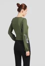 Camisa verde militar de viscosa con bordado floral blanco en el frente y mangas largas con puños elásticos.