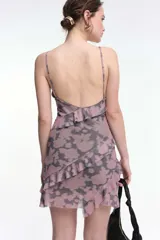 Vestido corto negro con lunares blancos, breteles finos y volados horizontales.