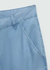 Pantalón celeste de lyocell, corte wide leg, tiro medio, con trabillas, bolsillos laterales y traseros.