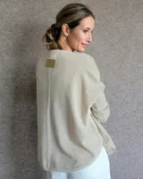 Buzo de lambswool color crema, con diseño holgado y manga larga, ideal para combinar con diferentes prendas.
