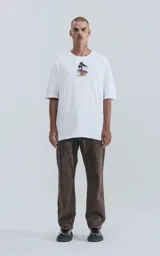 Remera blanca de algodón premium con cuello redondo y calce oversize. Presenta un estampado central de Mickey Mouse con patineta.