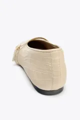 Bailarinas color crema de piel con tira delantera con hebilla y acabado en punta redonda.