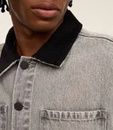 Campera trucker boxy de jeans gris con cuello de terciopelo negro, abotonada al frente, con bolsillos delanteros y mangas largas ajustadas.