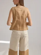 Chaleco color beige de lino con corte entallado y cierre frontal con botones de madera.