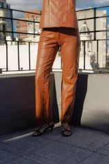 Pantalón de cuero color marrón con costuras verticales en el frente.