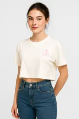 Remera cropped color crudo de algodón, corte holgado, cuello redondo y bordado pequeño en el pecho.