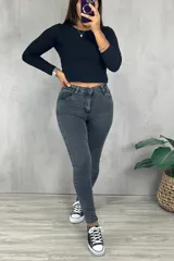 Pantalón chupín gris oscuro, tiro medio, con bolsillos delanteros y traseros.