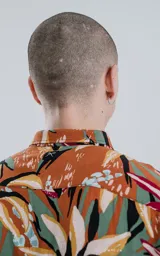 Camisa de manga larga con estampado de flores y hojas en tonos naranja, blanco, rojo, verde y negro.