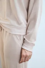Buzo rosa de tejido suave, calce relajado y ajuste en la cintura.