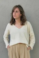 Sweater de punto color crudo con escote en V y mangas largas.