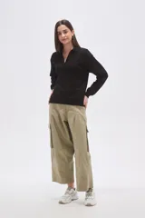 Buzo negro de manga larga con cuello polo y escote en V. Tiene un corte holgado y puños y dobladillo acanalados.