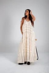 Vestido largo color crema con estampado geométrico lineal en negro, escote en V, breteles finos ajustables y bolsillos laterales.