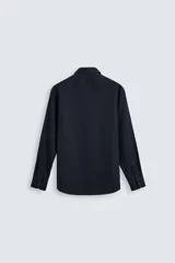 Camisa negra de manga larga con cuello italiano y cierre frontal de botonadura. Presenta un tejido con estructura de fácil cuidado.