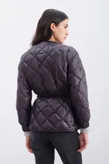 Campera de nylon color marrón, rellena de pluma, con cierre doble y cinturón elástico.