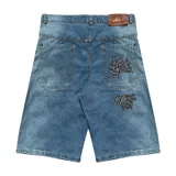 Bermuda baggy de jean celeste con lavado gastado en los laterales y bordados de letras chinas en negro y blanco.