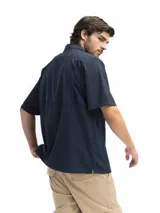 Camisa negra de manga corta con cuello clásico, cierre frontal con botones y bolsillo de parche en el pecho.