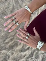 Brazalete rígido plateado con textura irregular.