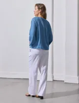 Blusa celeste de lyocell con cuello a la base y escote en V con lazo de ajuste. Manga larga amplia.