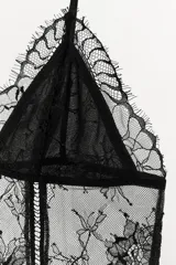 Top negro de encaje floral semitransparente con tirantes finos ajustables y escote en pico.