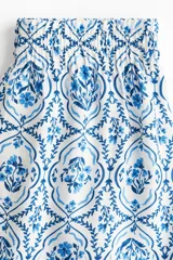 Short de sarga con estampado floral en tonos azules, bajo levemente redondeado, corte holgado, tiro alto y elástico revestido en la cintura.