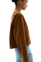 Chaqueta marrón de tejido suave con acabado cepillado, cuello redondo, cierre de botones adelante y bolsillos parche delanteros.
