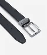 Cinturón social reversible negro y marrón de poliuretano con hebilla cuadrada metálica color plomo.