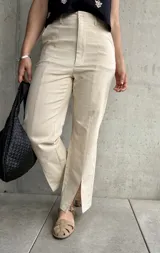 Pantalón color beige de lino, corte recto con abertura en el ruedo.