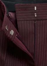 Pantalón de vestir color borgoña con finas rayas verticales, de tiro medio, corte recto y bolsillos traseros de ribete. Cierre frontal oculto con botón, gancho y cremallera.