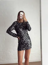 Minivestido negro con lentejuelas y estampado geométrico blanco.