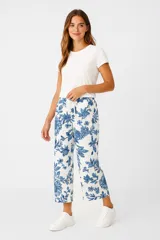 Pantalón capri blanco con estampado floral azul, de algodón y calce holgado.