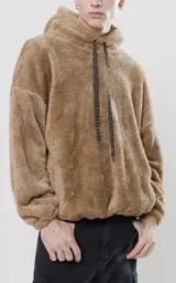 Hoodie beige de piel de corderito sintético, corte oversize con cierre central al estilo anorak, capucha con cordón ajustable y bolsillo canguro.