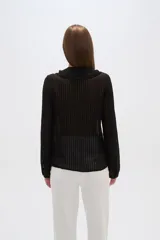 Blusa blanca de viscosa con cuello en V, volados frontales y cierre con botones.