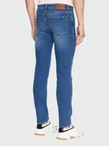 Pantalón de jean de corte recto, color azul medio, con bolsillos delanteros y traseros.