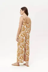 Mono largo de fibrana color camel con estampado abstracto en blanco, breteles finos y corte palazzo.