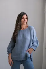 Blusa celeste de lino con mangas largas abullonadas y puños elásticos.