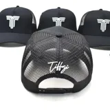 Gorro de gabardina negro con paneles de malla en la parte trasera y logo bordado en blanco en el frente.