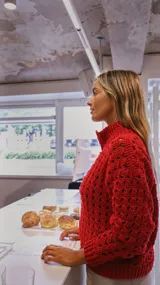 Campera color crudo tejida a crochet en algodón, con cuello alto y cierre frontal con cremallera.