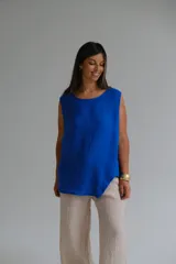 Musculosa azul francia confeccionada en lino italiano, de corte recto, con escote redondo y ruedo asimétrico.