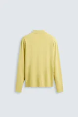 Polo de punto color amarillo claro, corte regular fit, tejido en hilatura con mezcla de algodón y lyocell. Cuello solapa con cierre frontal de botonadura y manga larga. Acabados en rib.