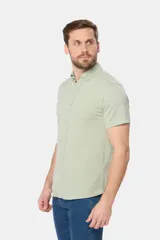 Camisa celeste de piqué con manga corta, botones personalizados y logo bordado a tono.