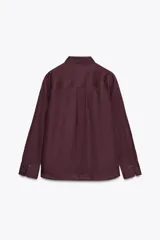 Camisa color ladrillo confeccionada en lino 100%, de corte recto, con cuello solapa, manga larga con puños y cierre frontal con botones.