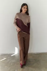 Buzo de punto con diseño geométrico en bloques de color gris y negro, de cuello redondo y mangas largas.