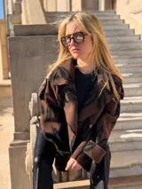 Chaqueta marrón con estampado animal print negro, cuello con solapas y cierre cruzado con botones.