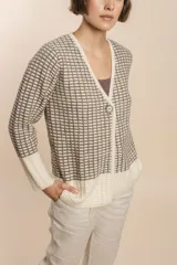 Cardigan tejido con efecto fantasia color crema. Una prenda de silueta amplia y cómoda. Tejido en 100% lana fina sin teñir.