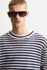 Jersey de punto con rayas horizontales en azul marino y blanco, cuello redondo y manga larga.