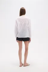 Blusa de algodón color menta, con escote en V, mangas largas y detalles de bordado floral y mostacillas en los hombros y el escote.